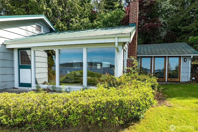 3115 Saratoga Rd, Langley, WA 98260 - view of property exterior with a sunroom, a chimney, metal roof, a yard, and a standing seam roof