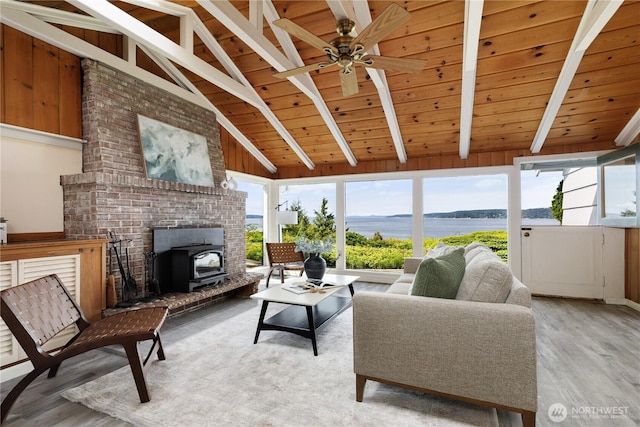 3115 Saratoga Rd, Langley, WA 98260 - living area with a wood stove, light wood-style floors, a water view, wooden ceiling, and a ceiling fan