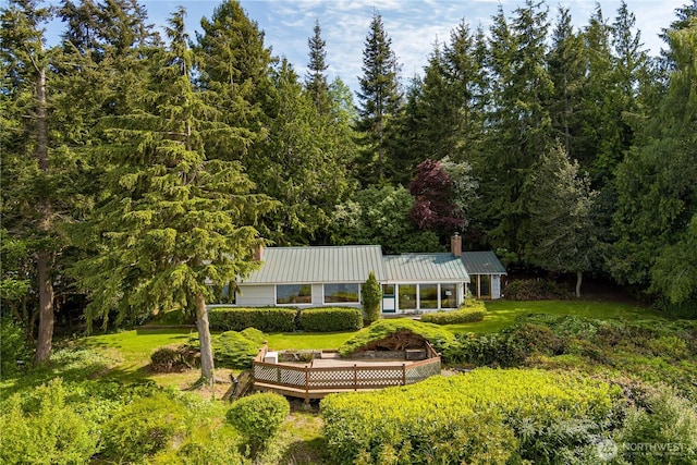 3115 Saratoga Rd, Langley, WA 98260 - back of house featuring a chimney, a deck, a view of trees, and metal roof