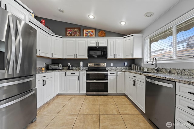 1032 Edgewater Ln, Moses Lake, WA 98837 - kitchen featuring stainless steel appliances, a sink, lofted ceiling, light tile patterned flooring, and white cabinetry