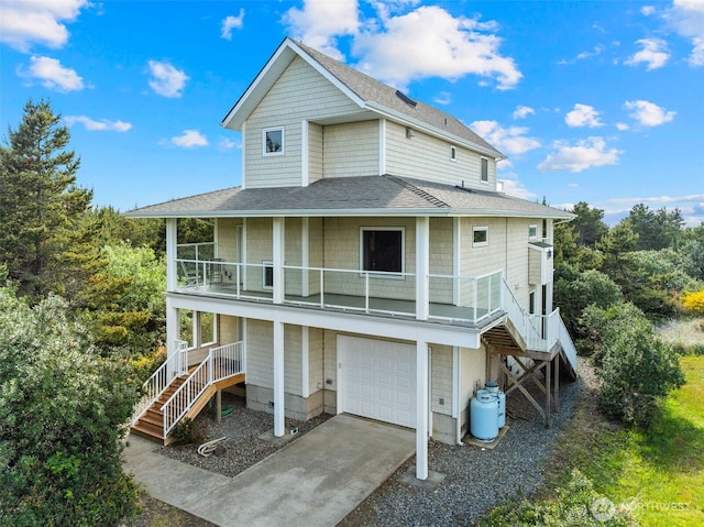 703 S Sand Dune Ave SW, Ocean Shores, WA 98569 - back of property featuring stairway, a garage, roof with shingles, a balcony, and driveway