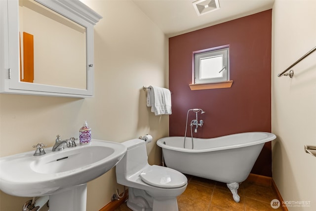 703 S Sand Dune Ave SW, Ocean Shores, WA 98569 - bathroom featuring a freestanding tub, a sink, toilet, tile patterned flooring, and baseboards