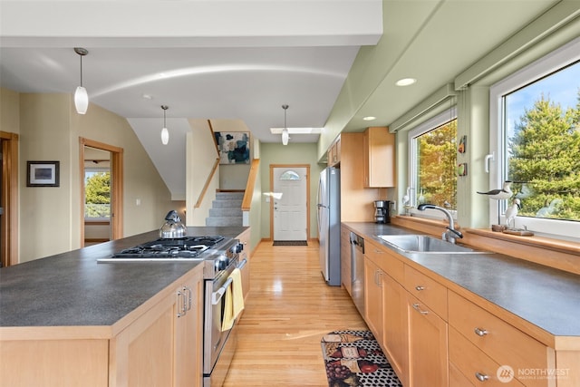 703 S Sand Dune Ave SW, Ocean Shores, WA 98569 - kitchen featuring appliances with stainless steel finishes, a sink, light brown cabinets, light wood-style flooring, and dark countertops