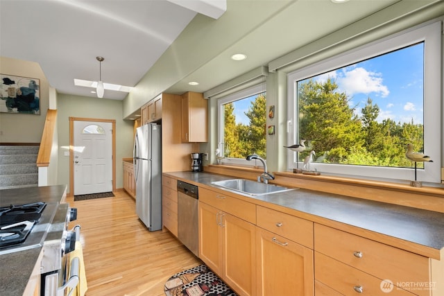 703 S Sand Dune Ave SW, Ocean Shores, WA 98569 - kitchen featuring stainless steel appliances, a sink, light wood finished floors, a skylight, and recessed lighting