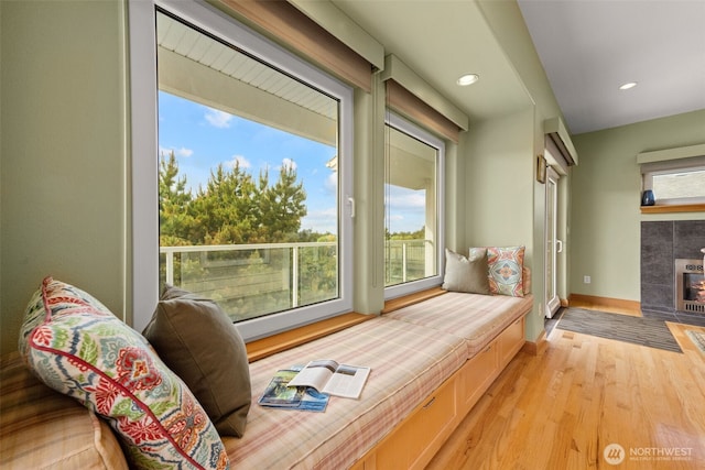 703 S Sand Dune Ave SW, Ocean Shores, WA 98569 - living area featuring healthy amount of natural light, light wood-type flooring, a tiled fireplace, baseboards, and recessed lighting