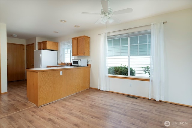 161 W Whidbey Ave Unit 4, Oak Harbor, WA 98277 - kitchen featuring white appliances, a peninsula, light wood finished floors, ceiling fan, and light countertops
