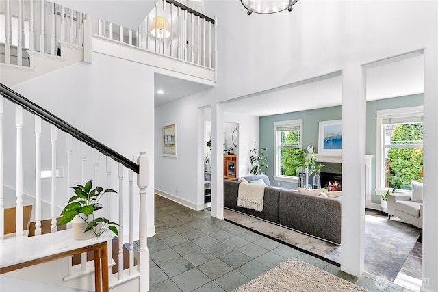 1014 Cherry Ave NE, Bainbridge Island, WA 98110 - foyer entrance featuring stairway, healthy amount of natural light, a tile fireplace, baseboards, and a towering ceiling