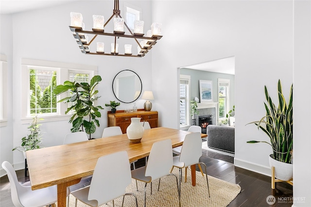 1014 Cherry Ave NE, Bainbridge Island, WA 98110 - dining space featuring a high ceiling, healthy amount of natural light, a tiled fireplace, dark wood finished floors, and baseboards