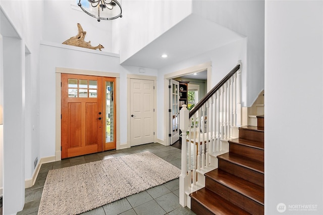 1014 Cherry Ave NE, Bainbridge Island, WA 98110 - entryway with tile patterned floors, stairway, a chandelier, baseboards, and a towering ceiling