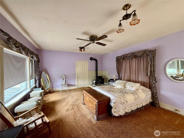 303307 N 3rd St, Dayton, WA 99328 - bedroom with a wood stove, carpet floors, baseboards, a ceiling fan, and a closet