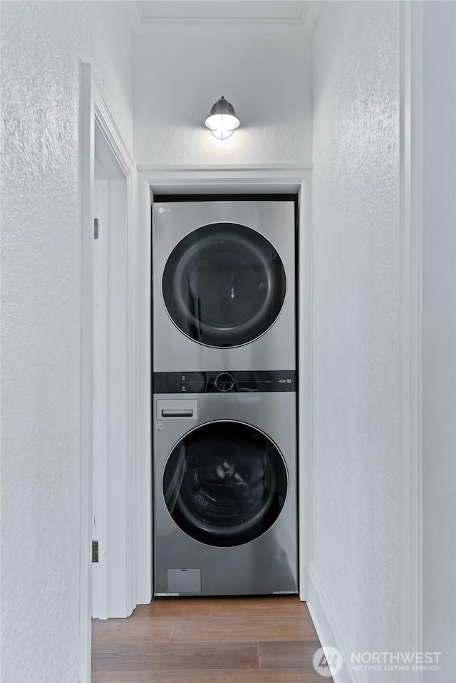 605 N Sampson St, Ellensburg, WA 98926 - washroom featuring estacked washer and dryer, a textured wall, and wood finished floors