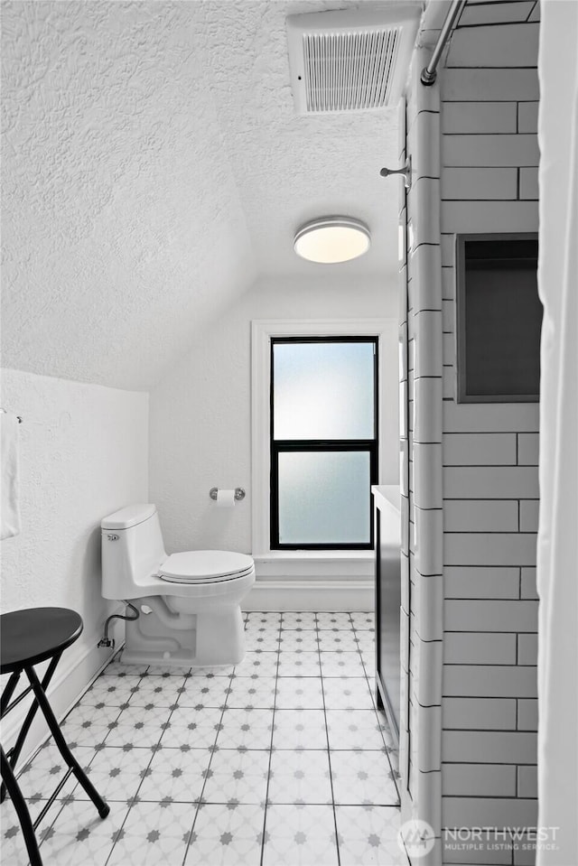 605 N Sampson St, Ellensburg, WA 98926 - full bathroom featuring a textured ceiling, lofted ceiling, toilet, baseboards, and a shower with curtain