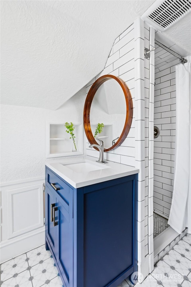 605 N Sampson St, Ellensburg, WA 98926 - full bathroom featuring vanity, a shower stall, wainscoting, and a decorative wall