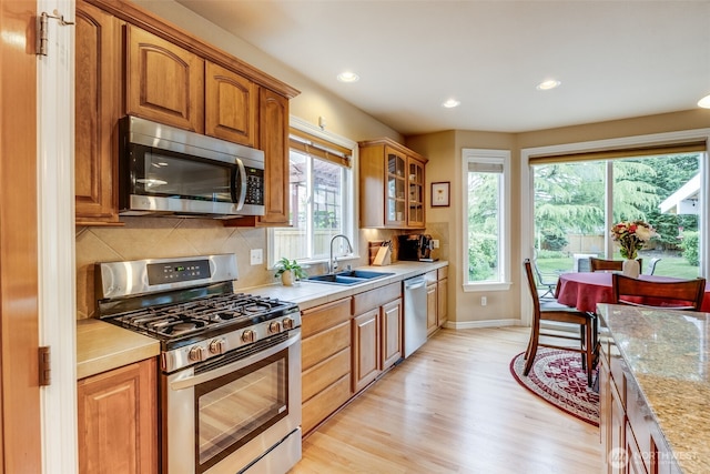 30630 122nd Ave SE, Auburn, WA 98092 - kitchen with stainless steel appliances, a sink, light wood-style flooring, baseboards, and tasteful backsplash