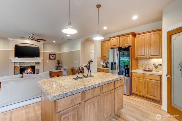 30630 122nd Ave SE, Auburn, WA 98092 - kitchen with stainless steel fridge with ice dispenser, light wood-type flooring, a center island, decorative backsplash, and a lit fireplace