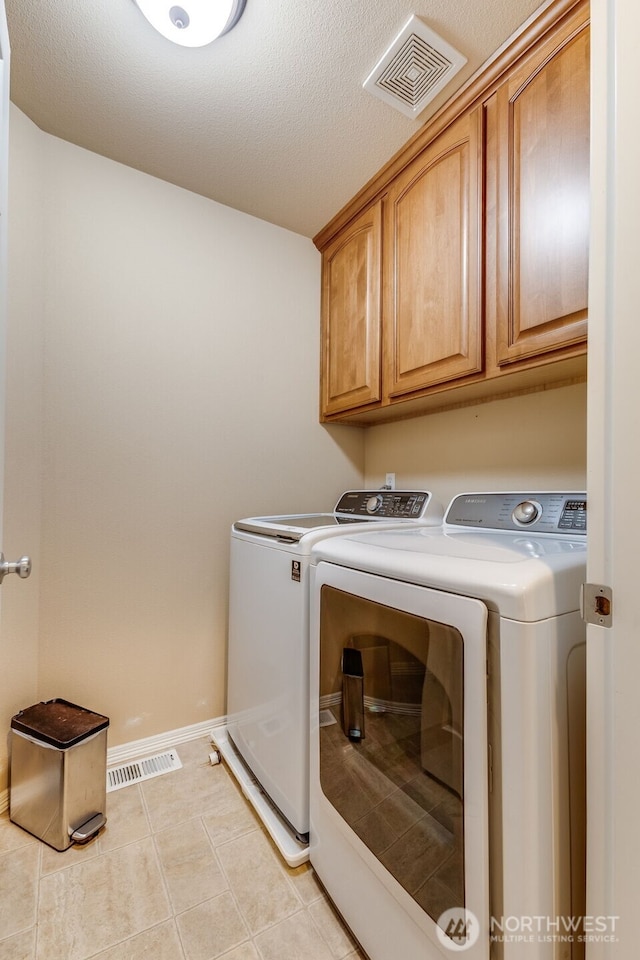 30630 122nd Ave SE, Auburn, WA 98092 - laundry room with cabinet space, washing machine and dryer, light tile patterned floors, and baseboards