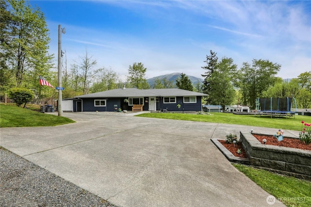 16015 Lange Rd, Mount Vernon, WA 98273 - ranch-style house with a trampoline, a front yard, a mountain view, and concrete driveway