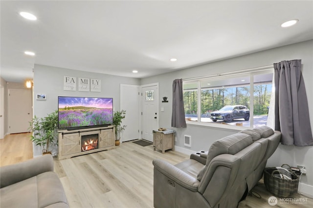 16015 Lange Rd, Mount Vernon, WA 98273 - living area with wood finished floors, recessed lighting, a lit fireplace, and baseboards
