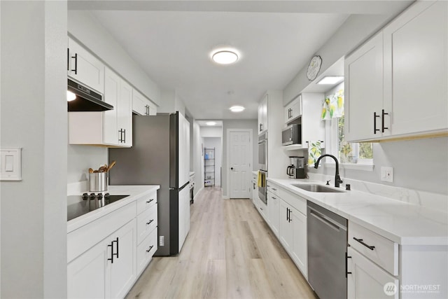 16015 Lange Rd, Mount Vernon, WA 98273 - kitchen with stainless steel appliances, a sink, under cabinet range hood, light wood finished floors, and white cabinetry