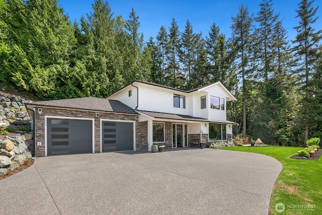 1048 Malvern Hills Dr, Camano Island, WA 98282 - view of front of home featuring driveway, an attached garage, stone siding, and a porch