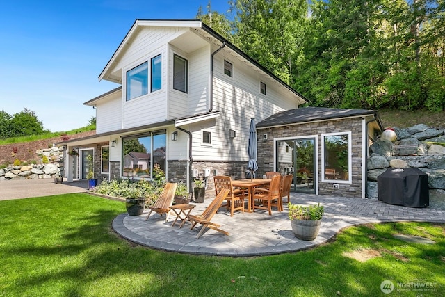 1048 Malvern Hills Dr, Camano Island, WA 98282 - rear view of house with a patio, stone siding, and a yard