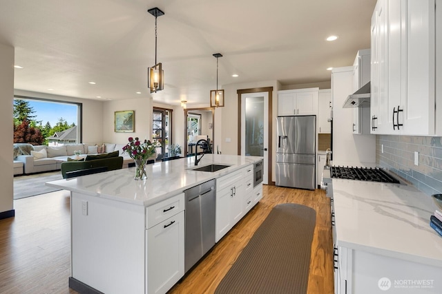 1048 Malvern Hills Dr, Camano Island, WA 98282 - kitchen featuring appliances with stainless steel finishes, light wood-type flooring, a sink, backsplash, and white cabinetry