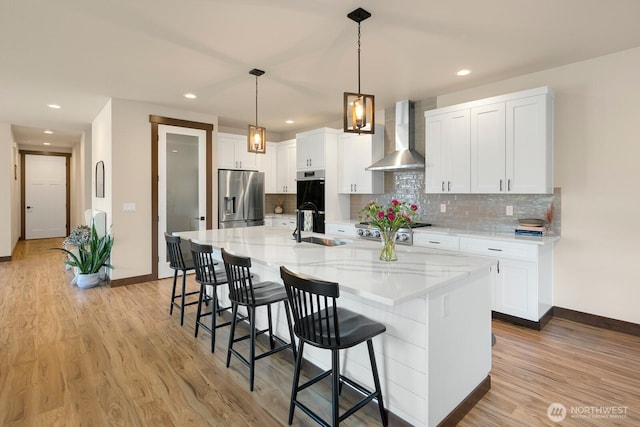 1048 Malvern Hills Dr, Camano Island, WA 98282 - kitchen featuring stainless steel fridge, wall chimney range hood, a sink, baseboards, and light wood-style flooring