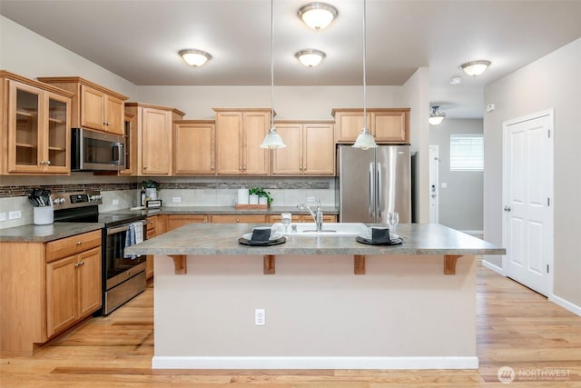 7628 Kodiak Ave NE, Lacey, WA 98516 - kitchen with appliances with stainless steel finishes, a kitchen breakfast bar, backsplash, and light wood-style floors