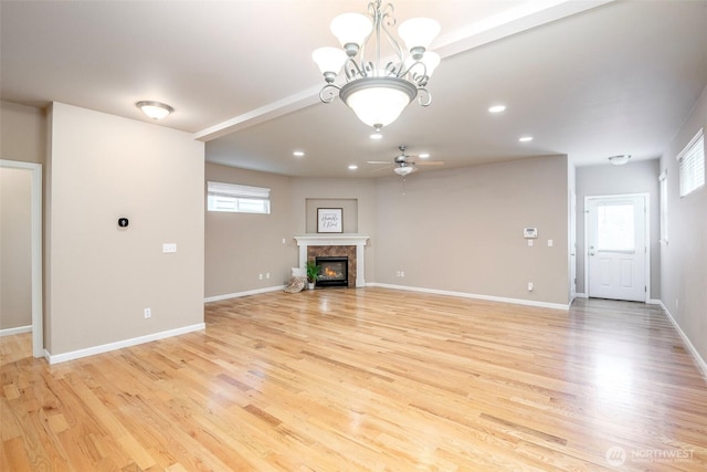 7628 Kodiak Ave NE, Lacey, WA 98516 - unfurnished living room featuring a ceiling fan, light wood-type flooring, a premium fireplace, a chandelier, and recessed lighting