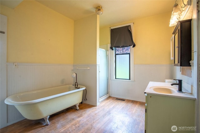 400 Augustus St, Toledo, WA 98591 - bathroom featuring a wainscoted wall, wood finished floors, vanity, a stall shower, and a freestanding tub