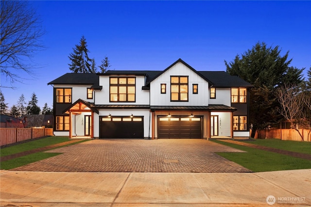 modern farmhouse style home with decorative driveway, an attached garage, a standing seam roof, metal roof, and board and batten siding