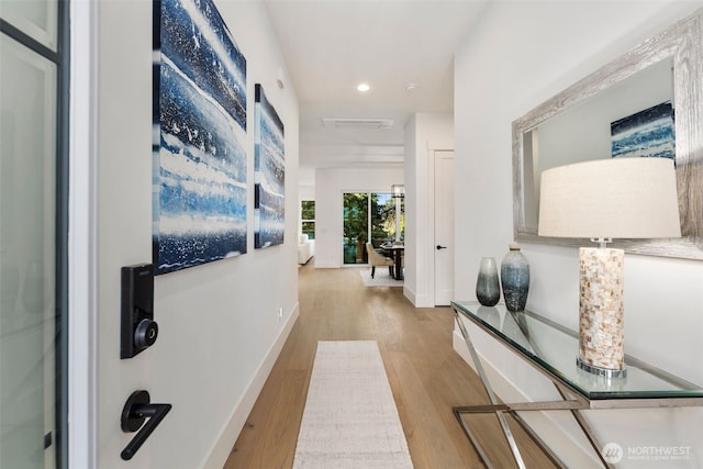 corridor with wood finished floors, recessed lighting, and baseboards