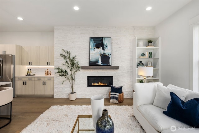 living room with dark wood-style floors, a fireplace, and recessed lighting
