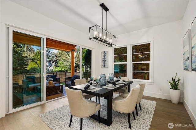 dining area with wood finished floors, baseboards, and a chandelier