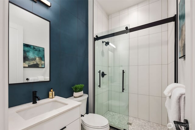 bathroom featuring a shower stall, toilet, and vanity
