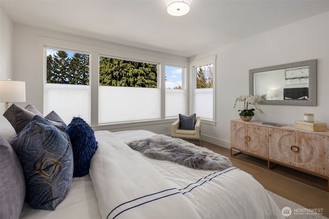 bedroom with wood finished floors and baseboards