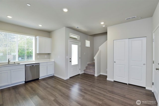 1308 E 53rd St, Tacoma, WA 98404 - kitchen featuring stainless steel dishwasher, a sink, light countertops, dark wood-style floors, and white cabinets
