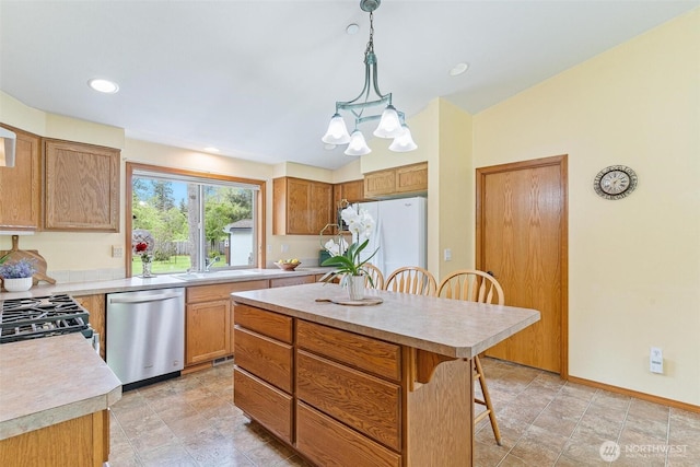 25420 354th Ave SE, Ravensdale, WA 98051 - kitchen featuring appliances with stainless steel finishes, light countertops, a kitchen bar, a sink, and lofted ceiling
