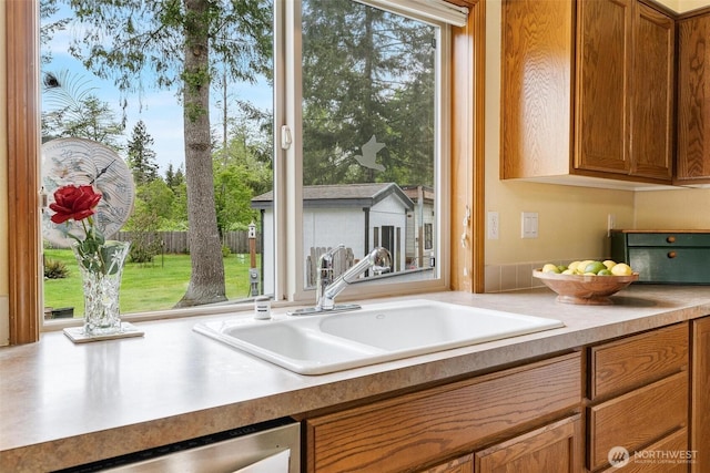 25420 354th Ave SE, Ravensdale, WA 98051 - kitchen with a sink, brown cabinets, stainless steel dishwasher, and plenty of natural light
