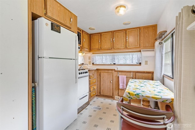 25420 354th Ave SE, Ravensdale, WA 98051 - kitchen with white appliances, light floors, brown cabinets, and light countertops