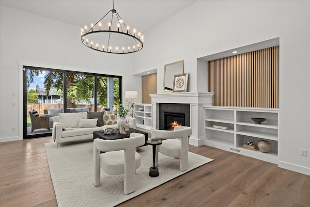 11440 109th Ave NE, Kirkland, WA 98033 - living room featuring a high ceiling, a chandelier, a tile fireplace, wood finished floors, and baseboards