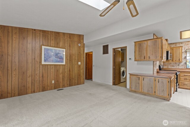 11436SE 208th St Unit 180, Kent, WA 98031 - kitchen featuring washer / dryer, stainless steel appliances, light carpet, ceiling fan, and wooden walls