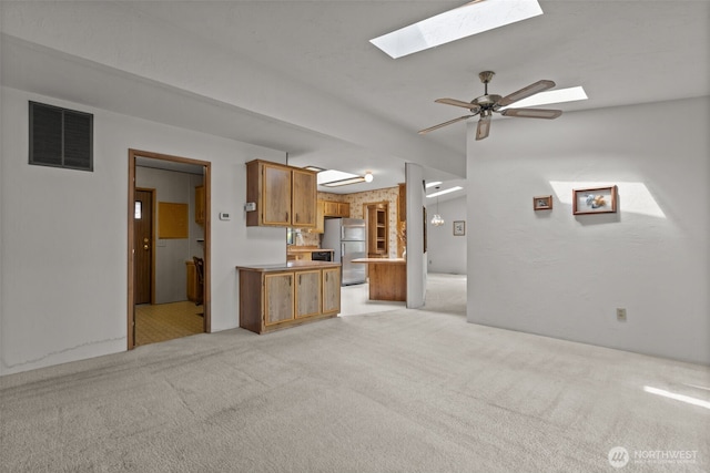 11436SE 208th St Unit 180, Kent, WA 98031 - kitchen with freestanding refrigerator, a skylight, brown cabinets, and light colored carpet