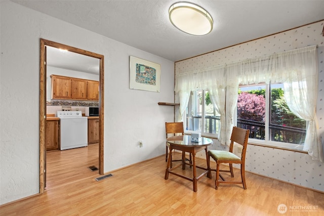 11436SE 208th St Unit 188, Kent, WA 98031 - dining space featuring washer / clothes dryer, light wood-style floors, and wallpapered walls