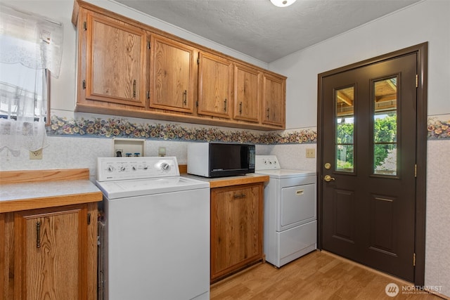 11436SE 208th St Unit 188, Kent, WA 98031 - washroom featuring cabinet space, light wood-type flooring, a textured ceiling, and washer and clothes dryer