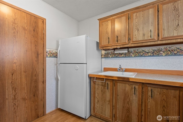 11436SE 208th St Unit 188, Kent, WA 98031 - kitchen with freestanding refrigerator, brown cabinetry, light wood-type flooring, and light countertops