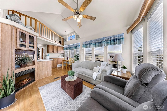 7704 Birch Bay Dr Unit 2805, Blaine, WA 98230 - living room with healthy amount of natural light, ceiling fan, high vaulted ceiling, a tile fireplace, and light wood-style flooring