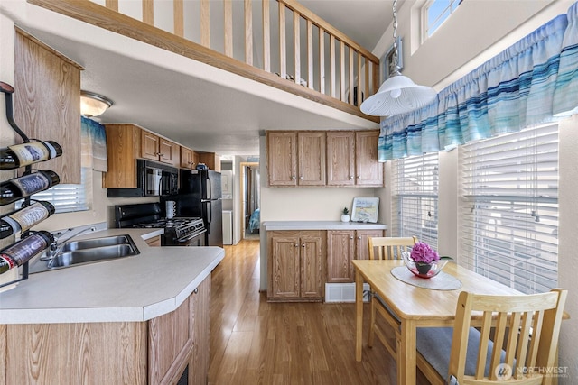 7704 Birch Bay Dr Unit 2805, Blaine, WA 98230 - kitchen featuring black appliances, a sink, light wood-type flooring, light countertops, and brown cabinetry