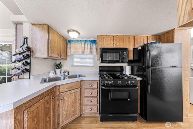 7704 Birch Bay Dr Unit 2805, Blaine, WA 98230 - kitchen featuring black appliances, a sink, light countertops, light wood-style floors, and a textured ceiling