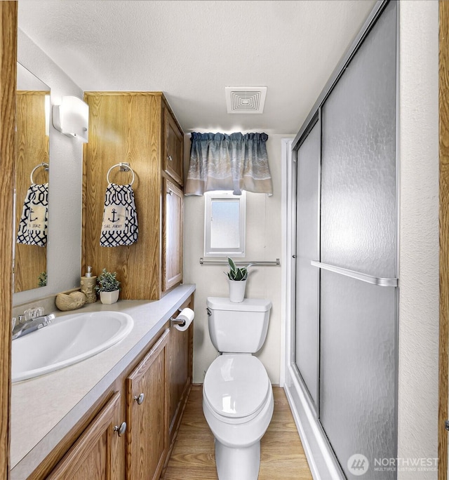 7704 Birch Bay Dr Unit 2805, Blaine, WA 98230 - bathroom with vanity, a shower stall, toilet, wood finished floors, and a textured ceiling